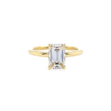 An 18K yellow gold solitaire emerald cut diamond ring 