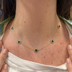 18K gold Necklace with green emerald gemstones worn by a woman
