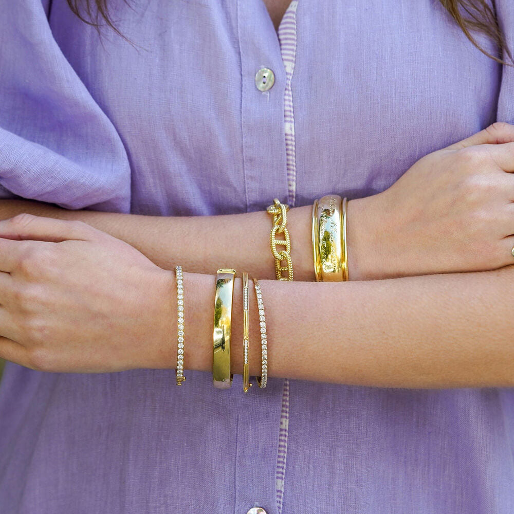 woman wearing multiple 18K gold bracelets offered by Laura Pearce Ltd.