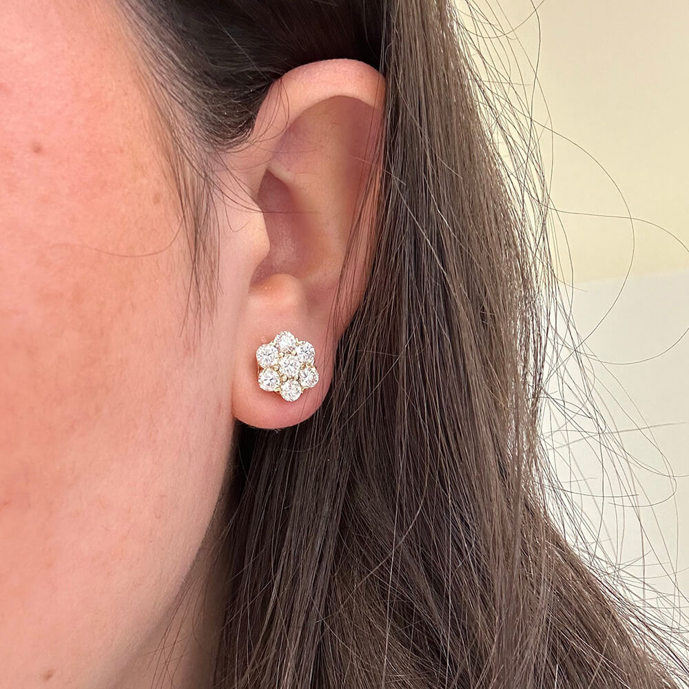Close-up of a woman's ear wearing an 18k gold diamond cluster earring
