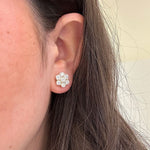 Close-up of a woman's ear wearing an 18k gold diamond cluster earring