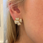 Close-up of a woman wearing an 18K gold heart clover earring with diamonds