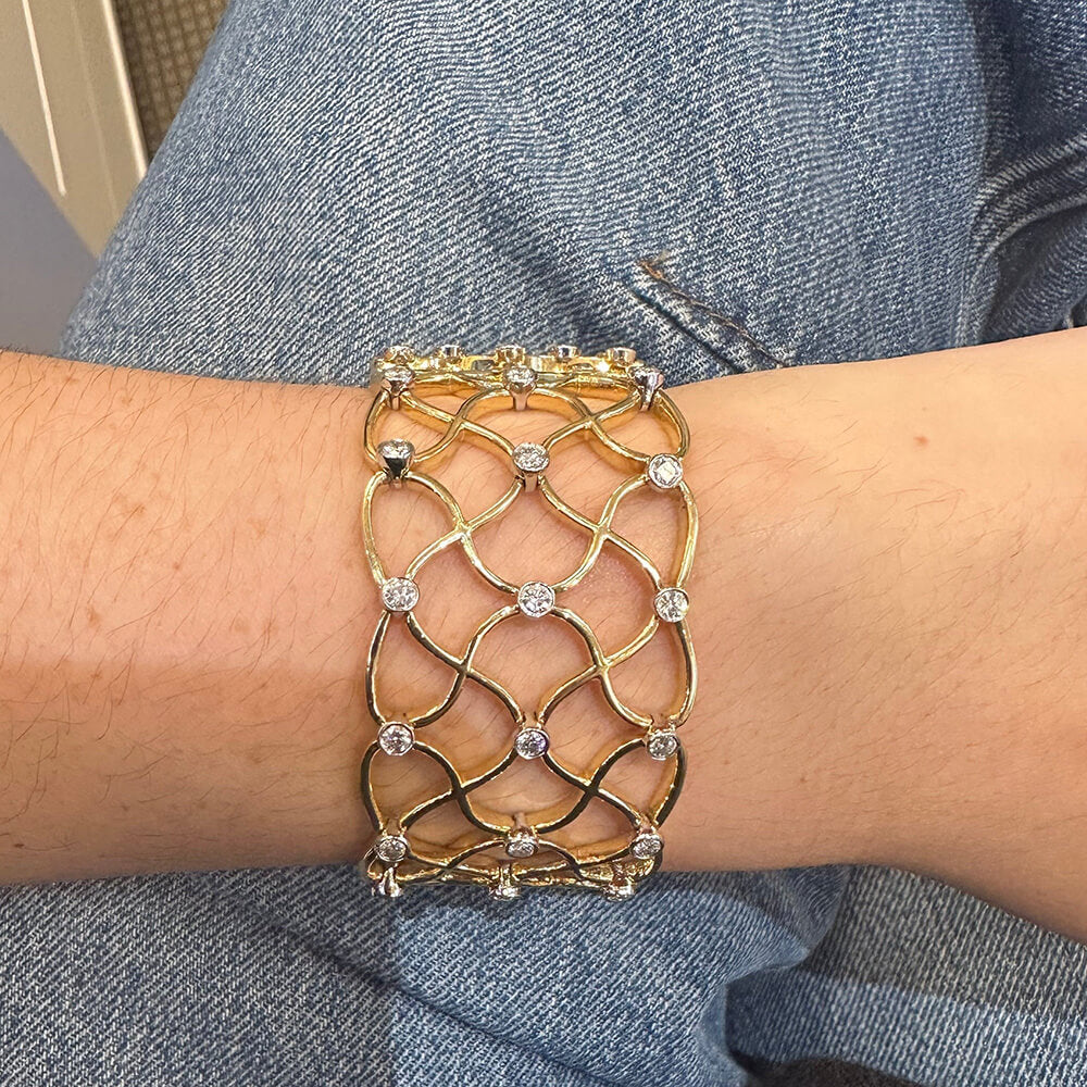 18K Gold bracelet with diamond accents on a wrist against a denim background