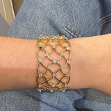 18K Gold bracelet with diamond accents on a wrist against a denim background