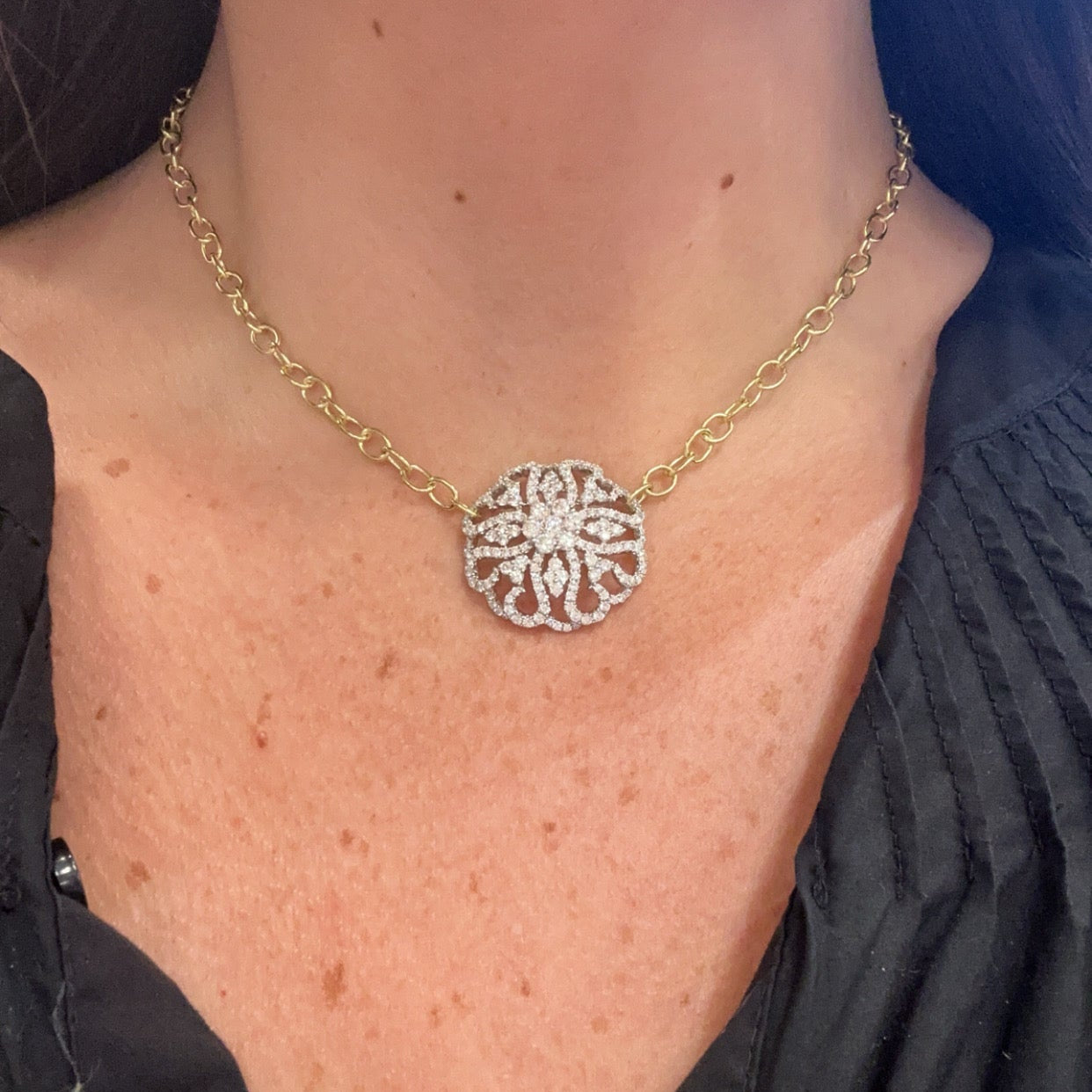 woman wearing 18K gold oval link chain with large diamond pendant