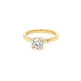 An 18K yellow gold solitaire diamond ring with a round center stone on a white background.