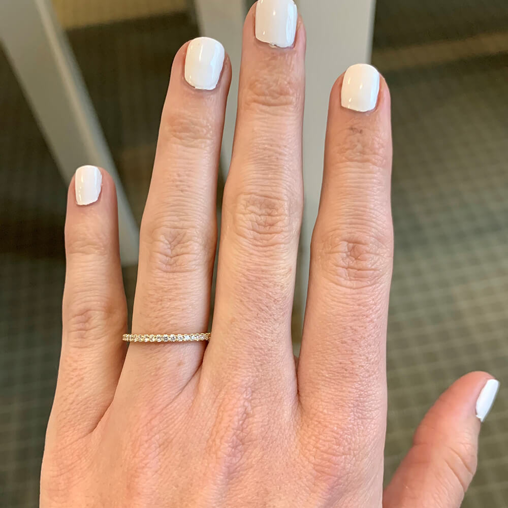 woman wearing shared prong set diamond band ring