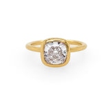 An 18K yellow gold bezel ring with a large square-cut diamond in the center.