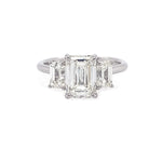 Diamond ring with three emerald-cut diamonds on a white background