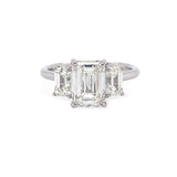 Diamond ring with three emerald-cut diamonds on a white background