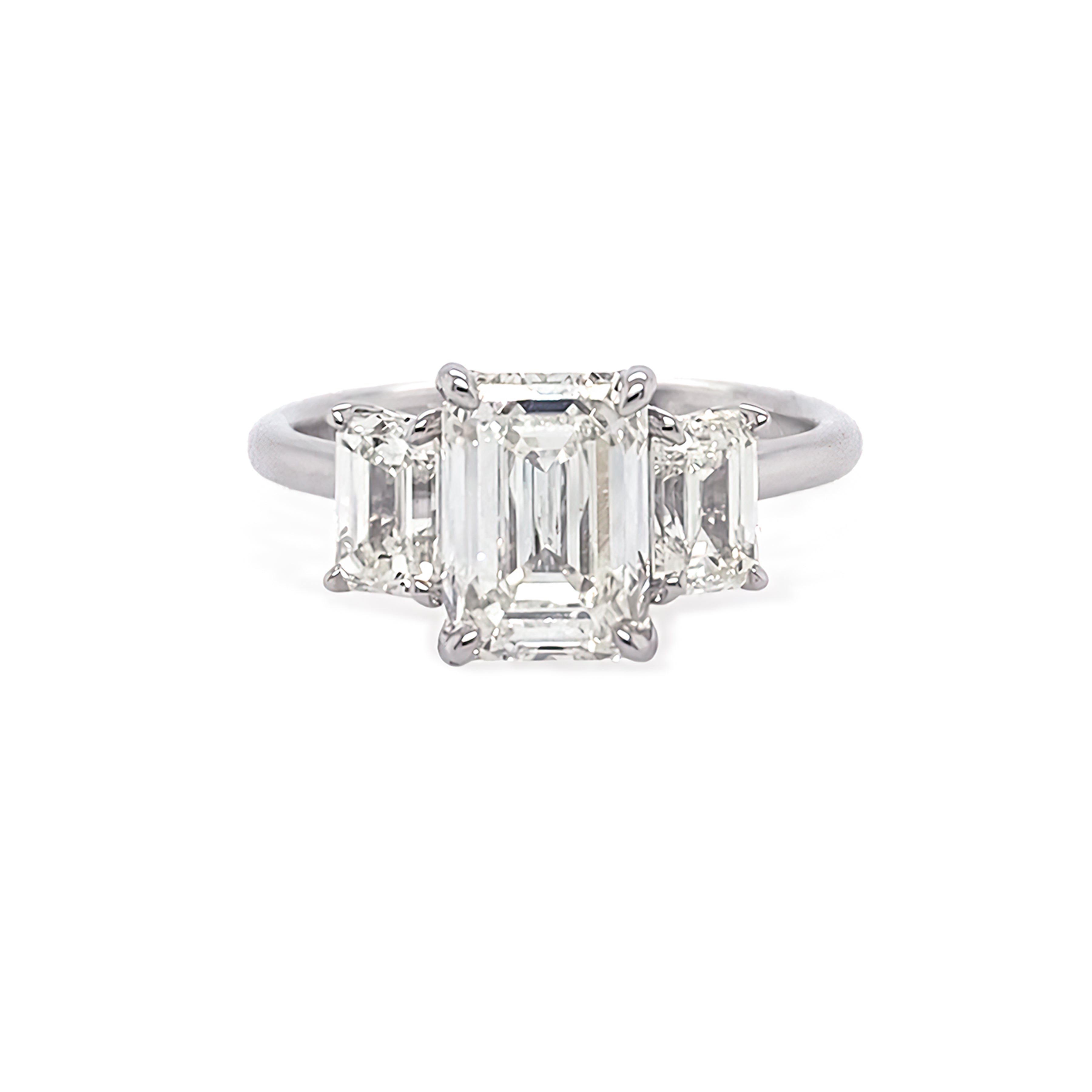 Diamond ring with three emerald-cut diamonds on a white background