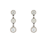 A pair of 18K white gold drop earrings, each featuring three graduated round-cut clear diamonds, shown against a plain white background.