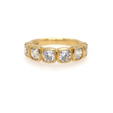 An 18K yellow gold bezel set band ring with six round diamond stones.