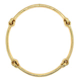 A polished 18k yellow gold necklace with four decorative knot-like accents spaced evenly around the circular band, shown on a plain white background.