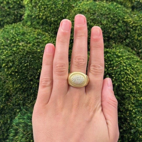 Woman's hand wearing a Kieselstein gold ring with diamonds