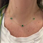 18k Gold necklace with green emerald gemstones worn by a woman