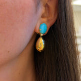 Close-up of a turquoise earring on an ear with blurred background