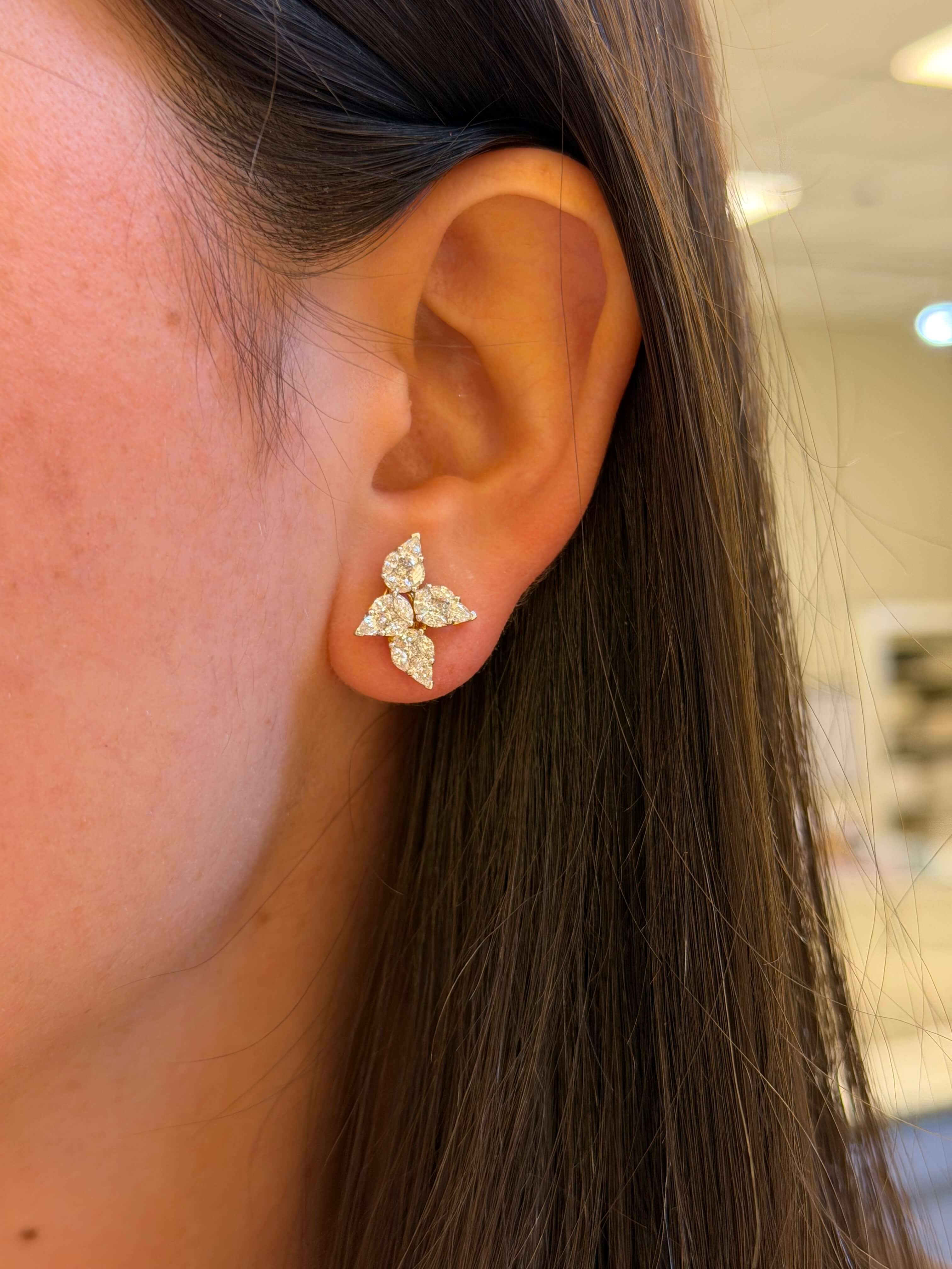 Close-up of an ear wearing a diamond earring with a blurred background