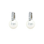 A pair of 18K white gold pearl and diamond earrings with the pearls hanging down.