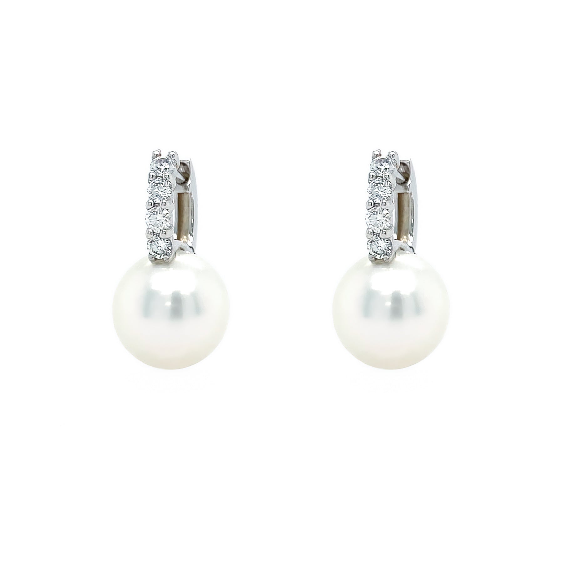 A pair of 18K white gold pearl and diamond earrings with the pearls hanging down.