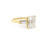 Gold ring with a large emerald cut diamond with taped baguettes 