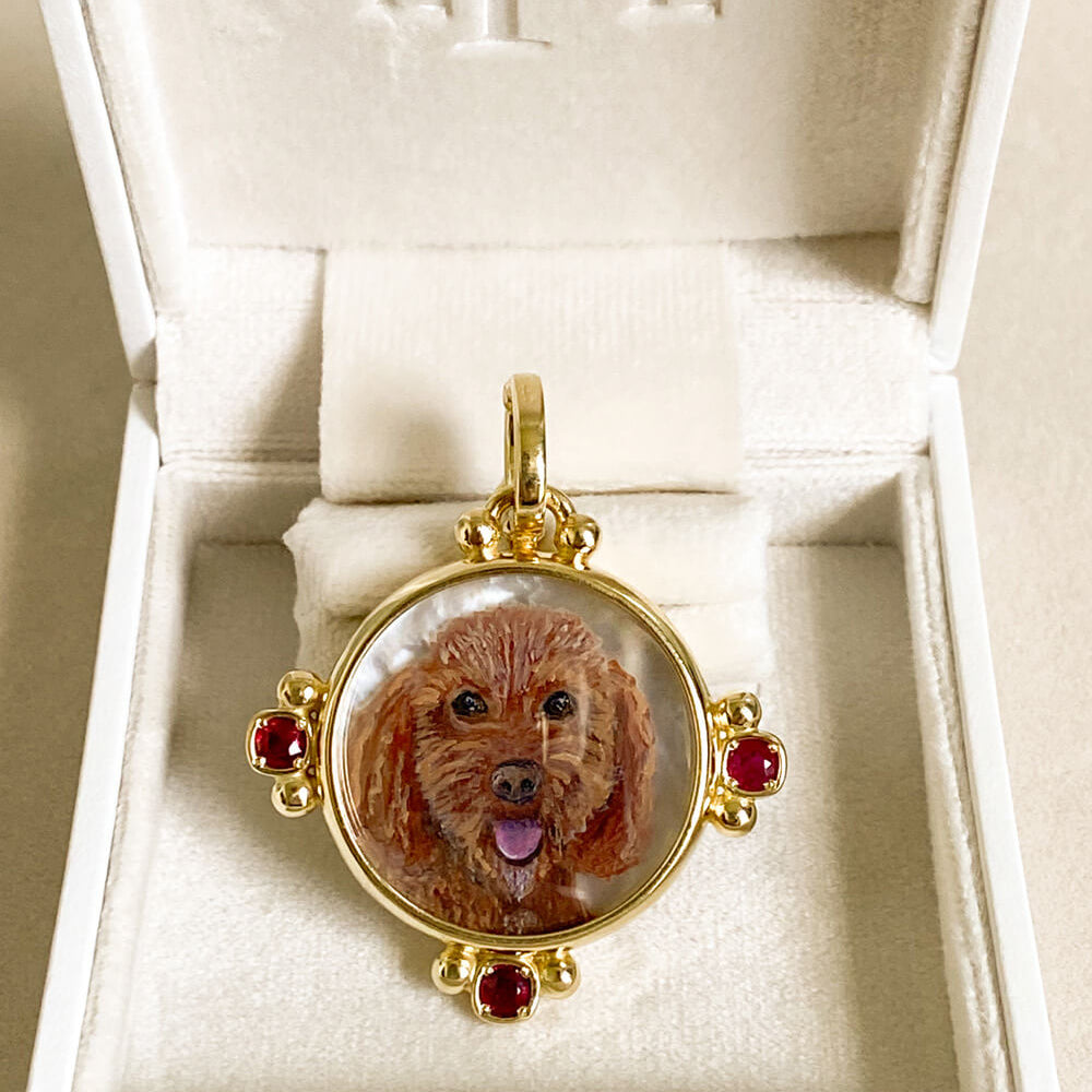 A round gold pendant featuring a custom portrait of a brown dog, displayed inside an open white jewelry box with the brand name 'LPL' embossed on the inside lid.