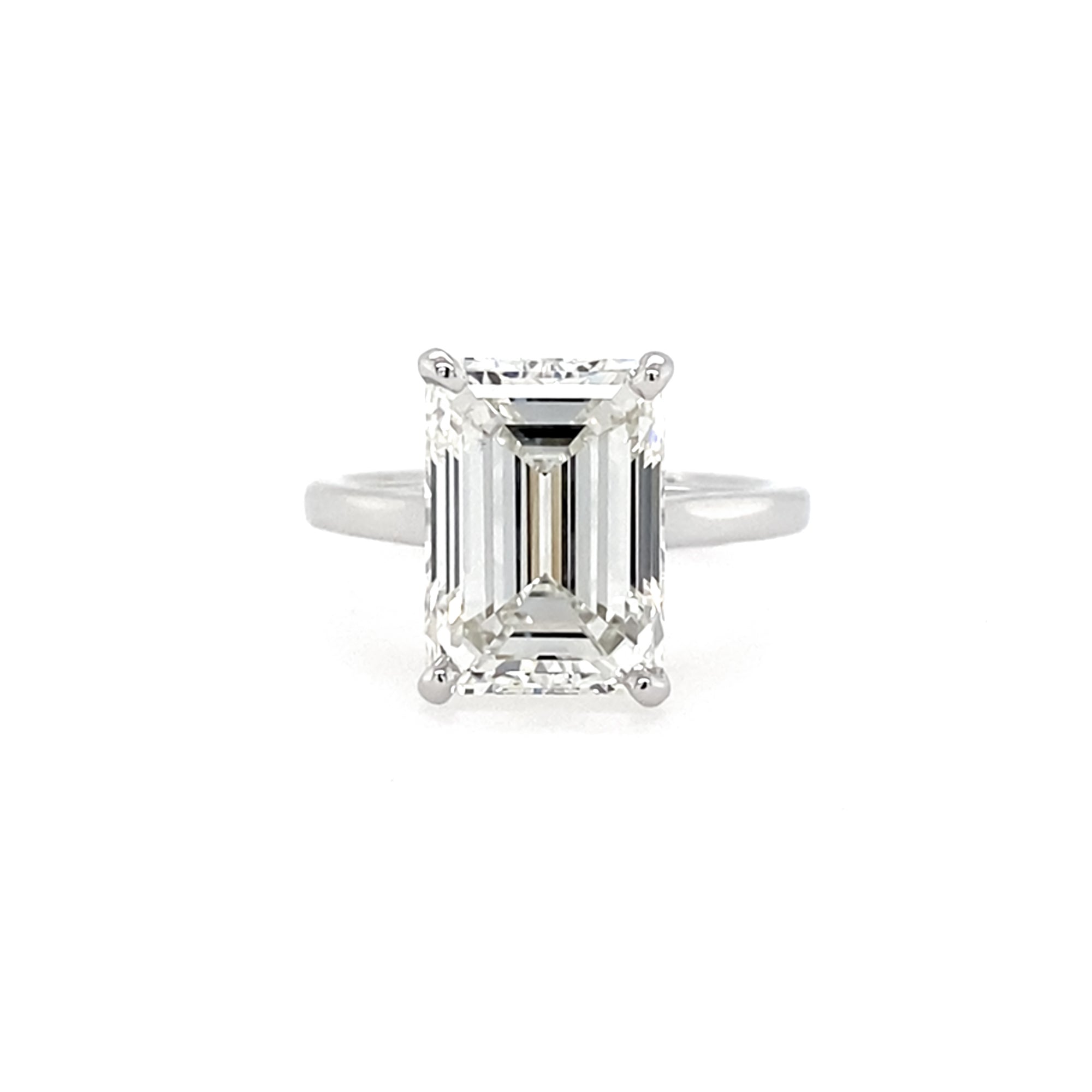 Diamond ring with emerald-cut diamond on a white background