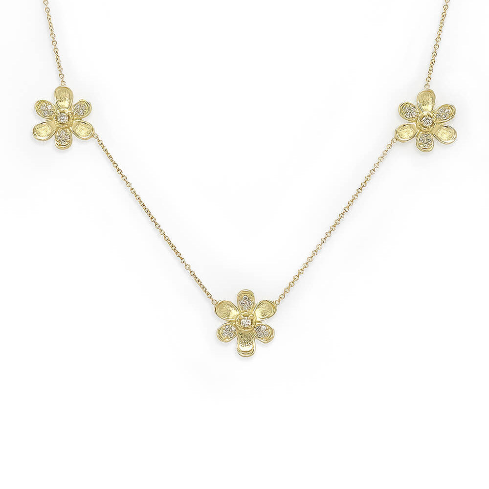 A delicate 18K yellow gold chain necklace featuring three small flower-shaped pendants, each adorned with tiny clear diamonds, displayed on a clean white background.
