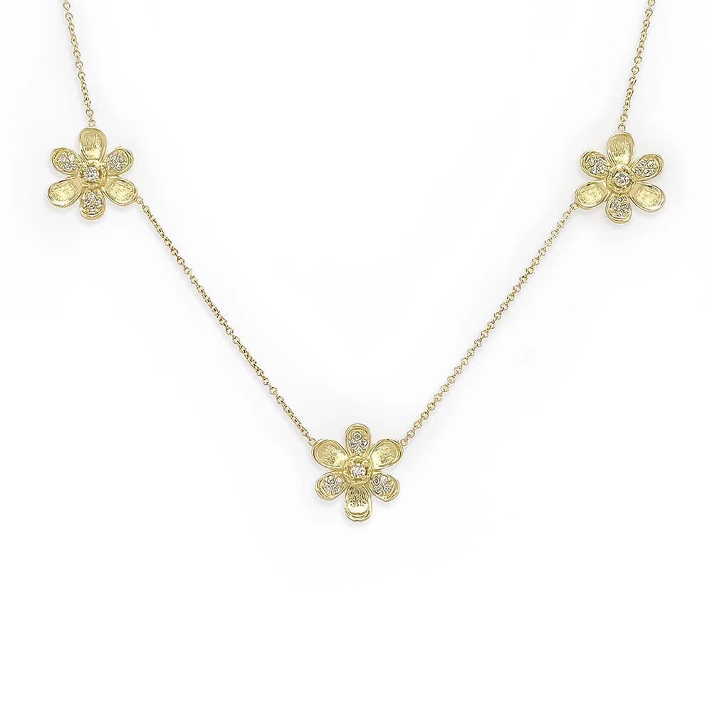 A delicate 18K yellow gold chain necklace featuring three small flower-shaped pendants, each adorned with tiny clear diamonds, displayed on a clean white background.