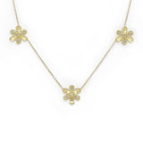 A delicate 18K yellow gold chain necklace featuring three small flower-shaped pendants, each adorned with tiny clear diamonds, displayed on a clean white background.