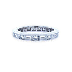 A platinum eternity band with baguette and round diamonds set around its circumference.