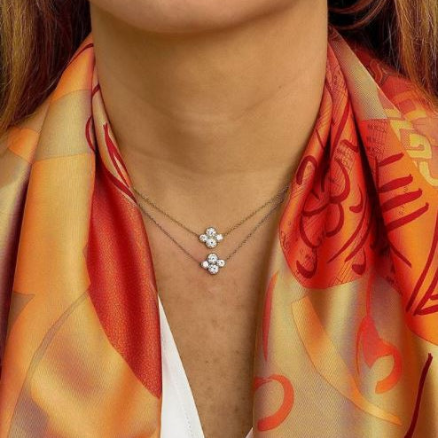 Close-up of a woman wearing 2 Platinum diamond necklaces designed by Laura Pearce.
