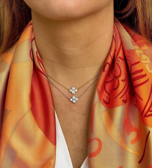Close-up of a woman wearing 2 Platinum diamond necklaces designed by Laura Pearce.