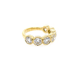 An 18kt yellow gold band ring with bezel set round diamonds.