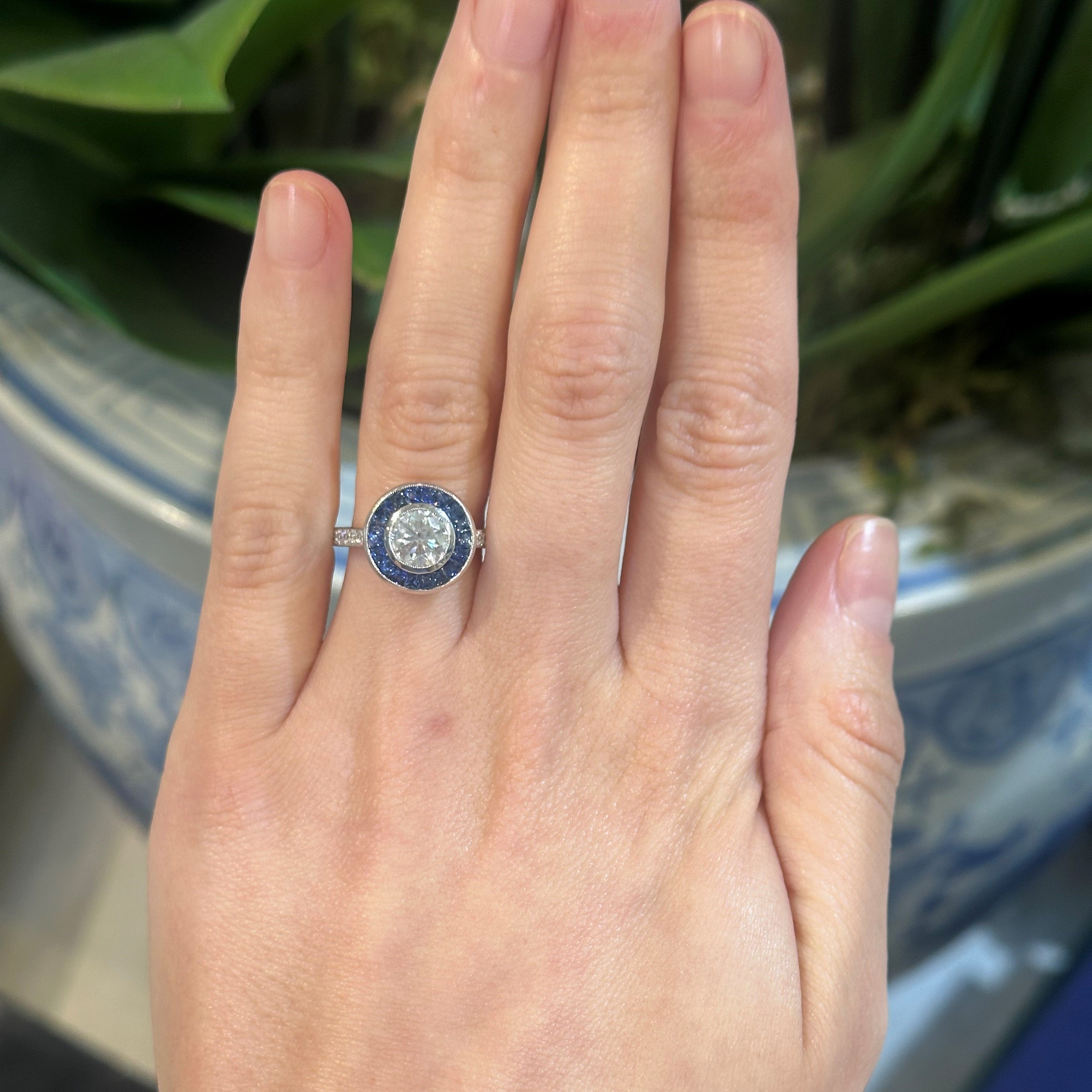 woman wearing an art deco bullseye diamond and sapphire ring