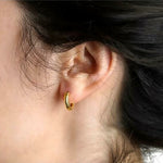 Close-up of a woman wearing Elizabeth Locke 19K Hammered Gold hoop earrings