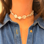 Woman wearing a baroque pearl choker with a denim shirt