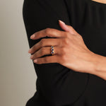 Woman wearing a blue sapphire ring with a black background