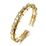 A 14Kgold cuff bracelet featuring a segmented design, beaded borders, and clear round diamonds, shown on a clean white background.