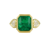 An 18kt yellow gold ring with a large green emerald and diamond heart shaped stones.