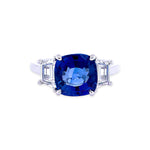 Custom designed ring featuring a cushion cut sapphire and trapezoid side diamonds in a platinum setting