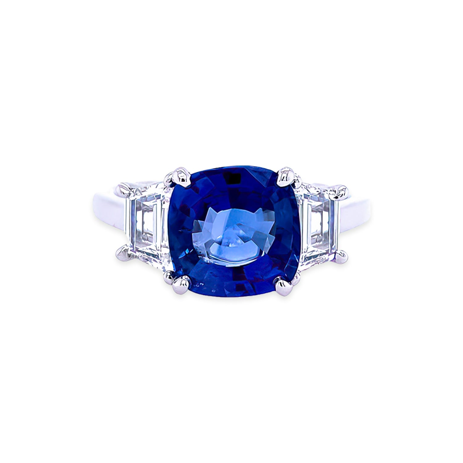 Custom designed ring featuring a cushion cut sapphire and trapezoid side diamonds in a platinum setting