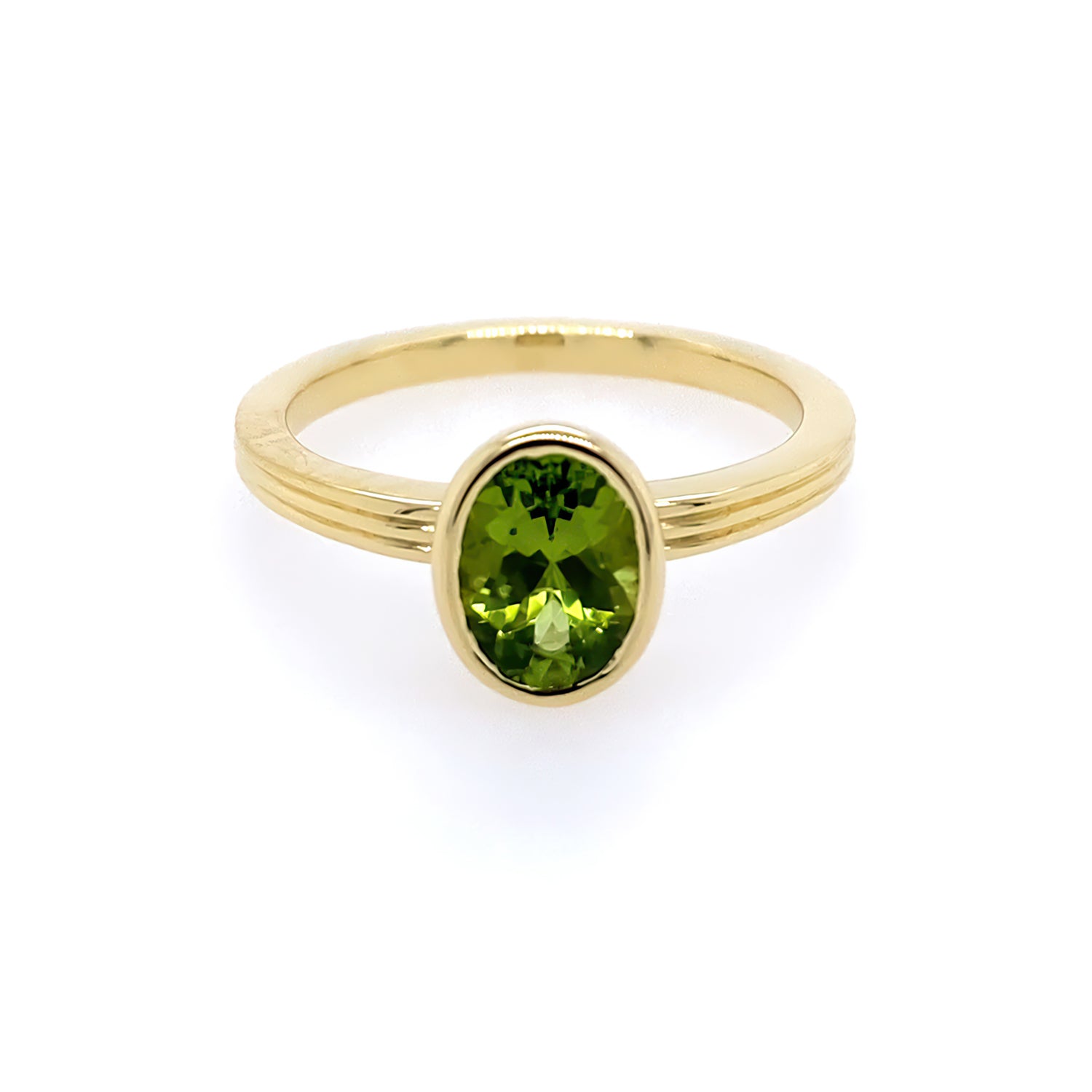 An 18kt yellow gold ring with a green peridot centerpiece, presented against a white background.