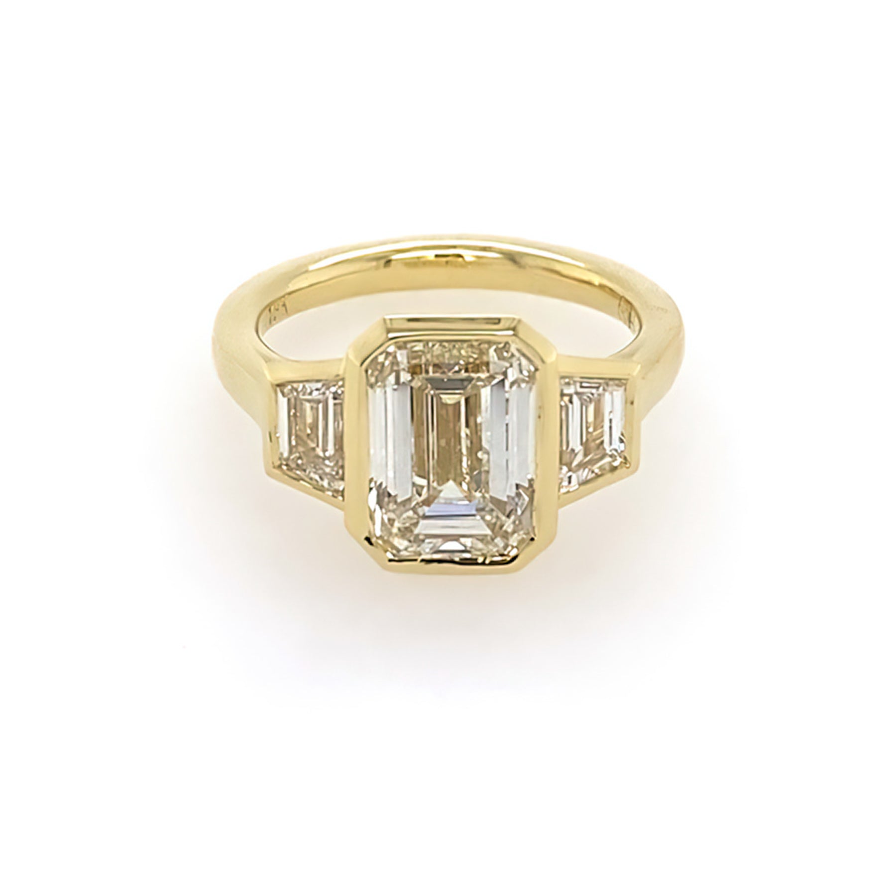 18k yellow gold bezel set emerald cut engagement ring with trapezoid side stones 