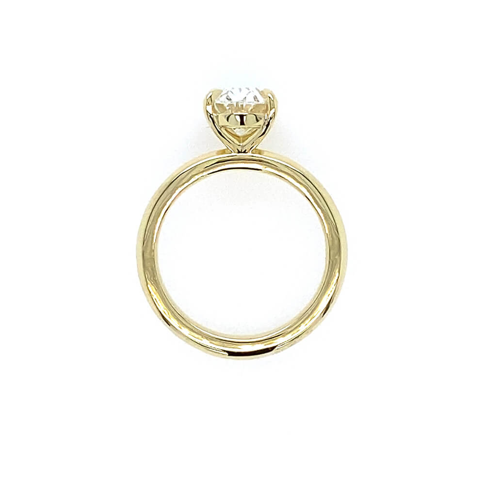 An 18K yellow gold ring with a single oval-cut clear diamond in a prong setting, shown against a plain white background.