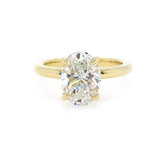 An 18K yellow gold ring featuring a large oval-cut diamond in a four-prong setting, shown against a plain white background.