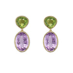 A pair of 18K yellow gold earrings featuring a large oval amethyst stone suspended from a smaller round peridot stone, set against a white background.