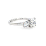 Round brilliant cut three stone diamond engagement ring in platinum - side view