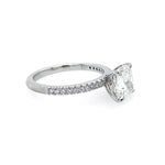 A platinum diamond engagement ring featuring a large cushion-cut center stone in a four-prong setting, with a pavé band of small round diamonds on a white background.