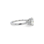 A platinum ring featuring a rectangular clear center diamond and two smaller side diamonds, shown from a side view on a plain white background.